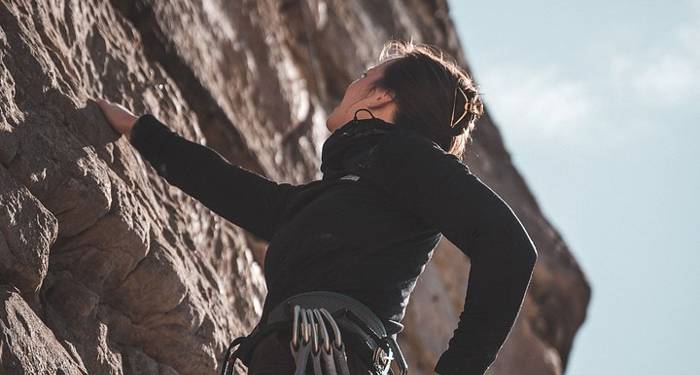 Women climbing rock wall