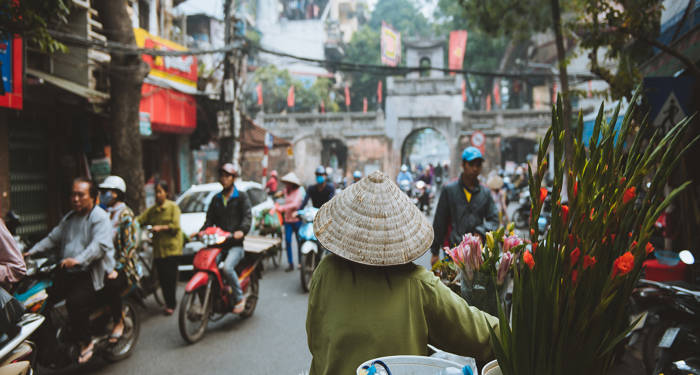 kvinne med tradisjonell hatt i gatene i Hanoi