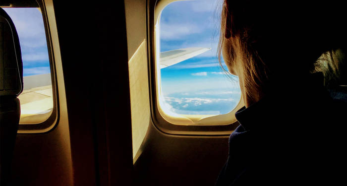 Traveling Alone Girl Looking Out Of A Plane