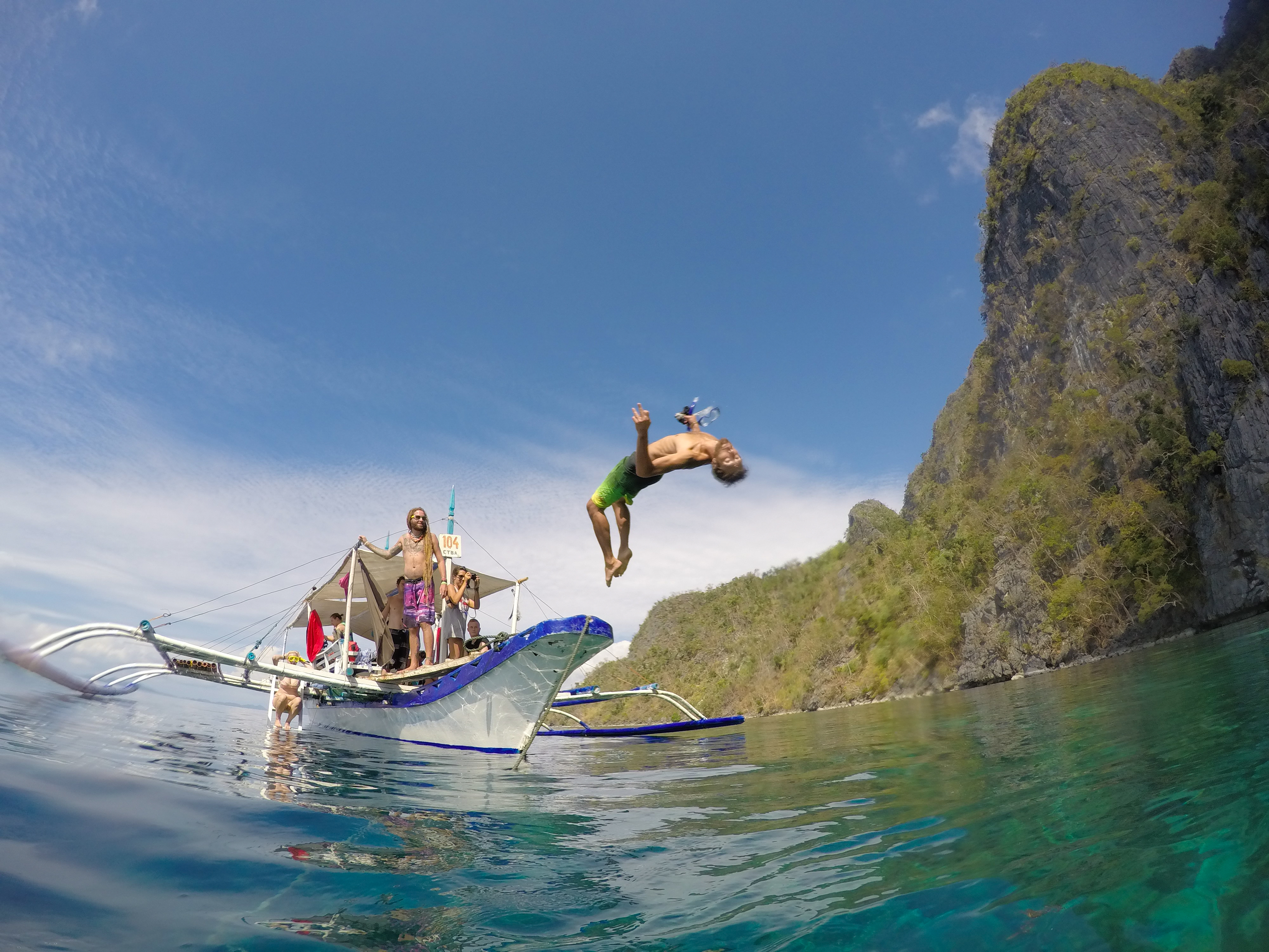 Bilde av en mann som hopper fra en seilbåt på Filippinene - KILROY