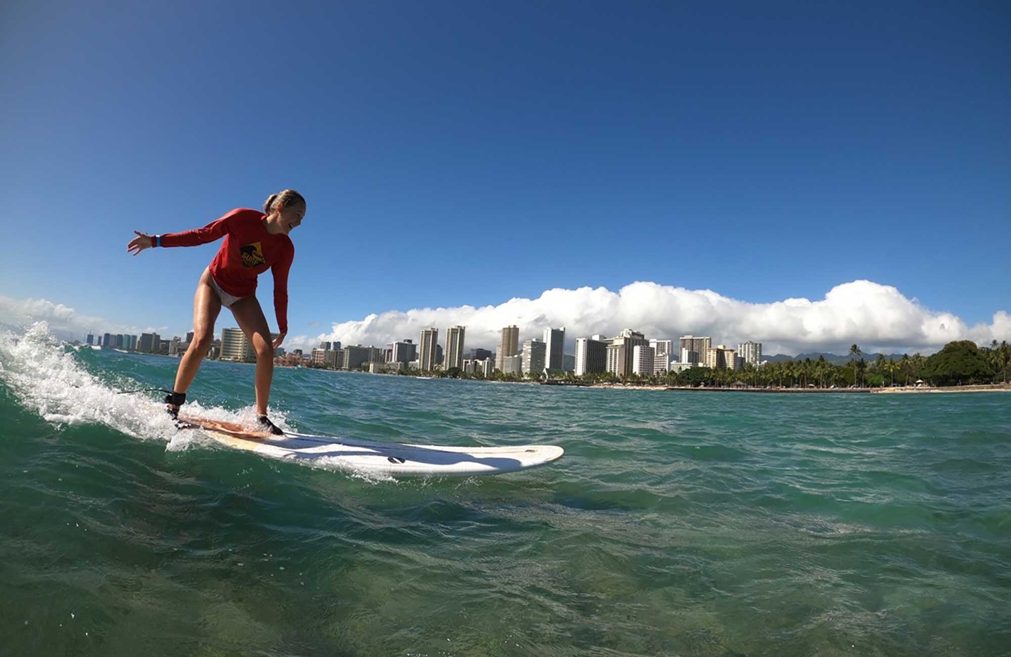 Jente som surfer i Honolulu, Hawaii