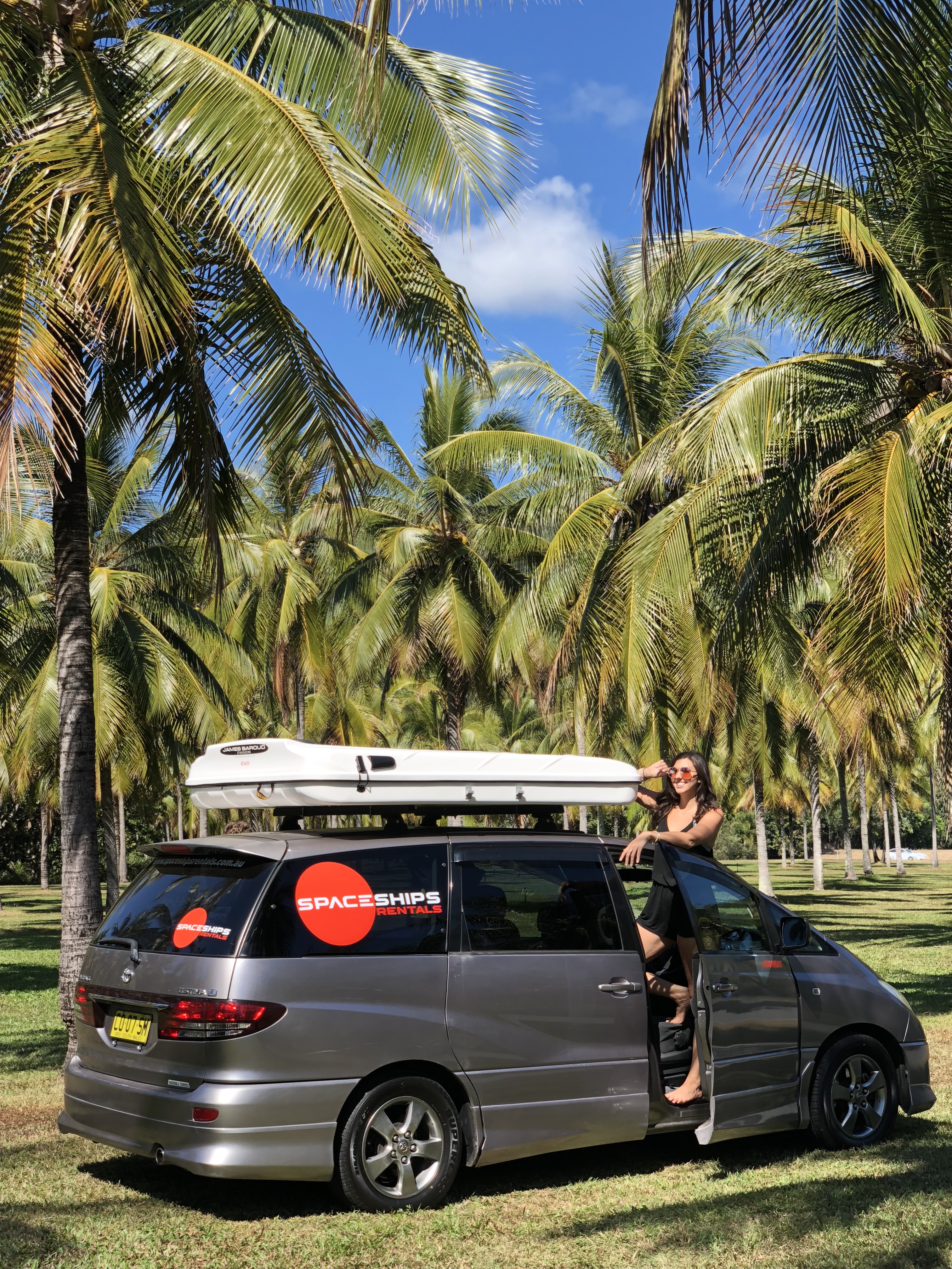 Kvinne som står i døråpningen på en grå Spaceships 4-berth campervan. 